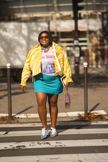 Gabriella Karefa-Johnson a blue mini skirt, graphic tee, and printed yellow jacket in Paris, France.