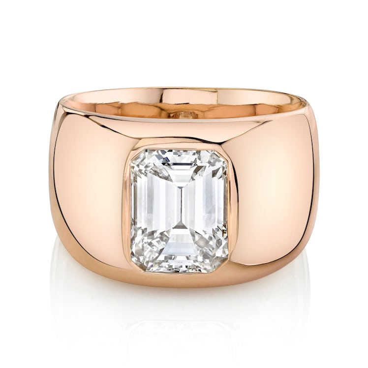 An emerald cut diamond engagement ring set in a thick band by Lizzie Mandler
