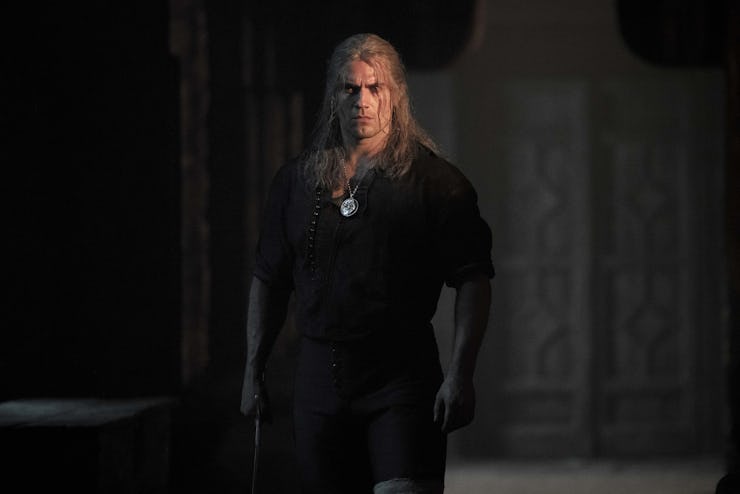 The Witcher standing alone in the dark