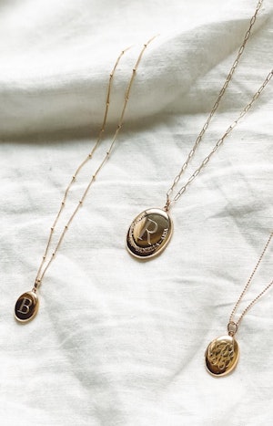 Gold oval locket necklaces by Sarah Chloe.