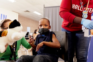 A young boy Zyon Moore looks toward the camera as he gets his vaccine