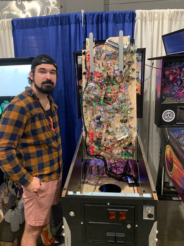 Matt Benzik shows off the innards of Motor City Taxi pinball game