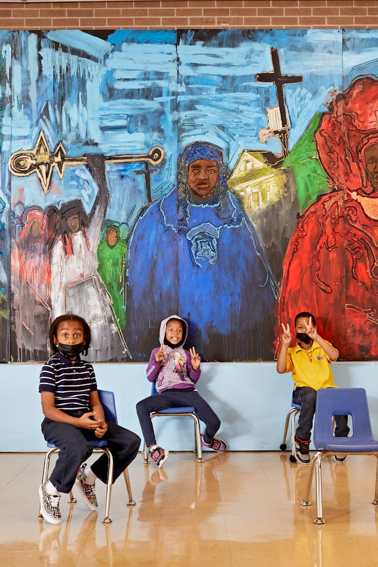 John, Tia Fortune, and Mayson Grace, sitting under the mural at KIPP Central City Elementary