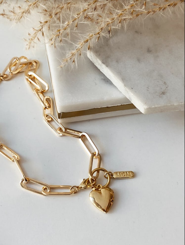A gold heart locket on a chainlink necklace by Océanne