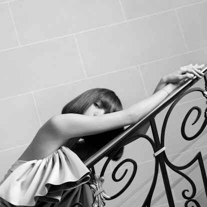 Blackpink's Lisa leaning with her arm on a stairway railing