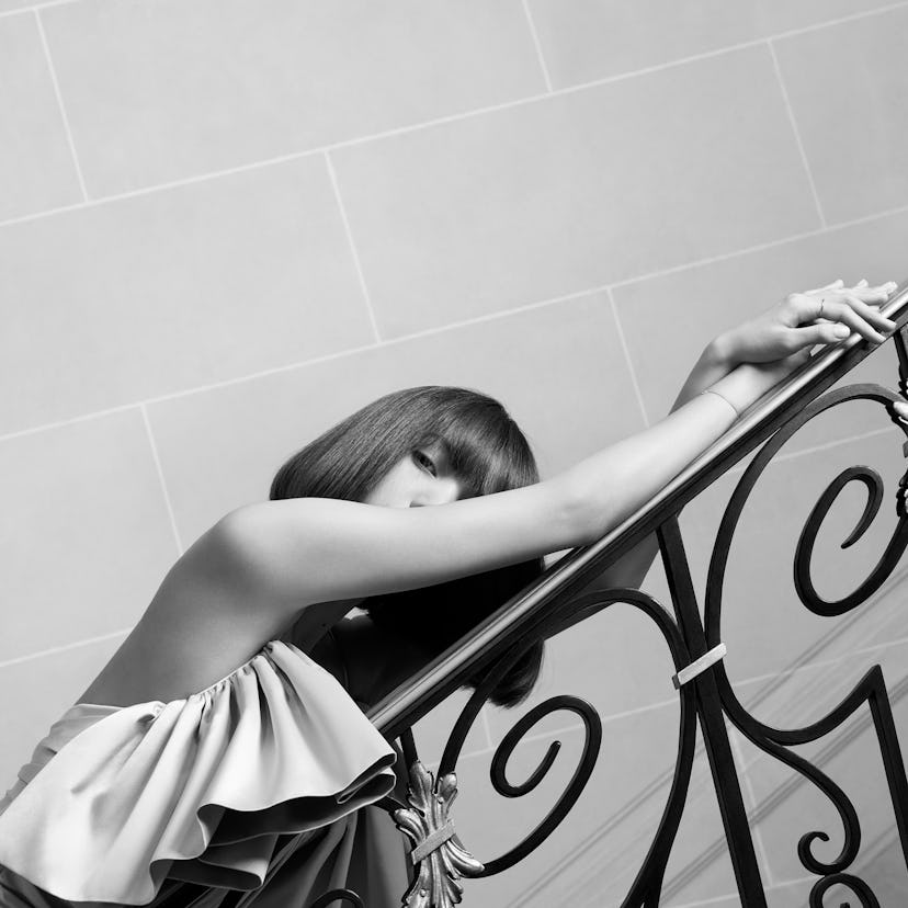 Blackpink's Lisa leaning with her arm on a stairway railing