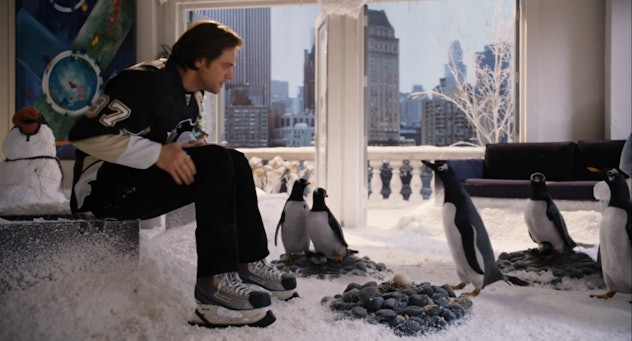 Jim Carrey sits among a flock of penguins in his apartment in Mr. Popper's Penguins