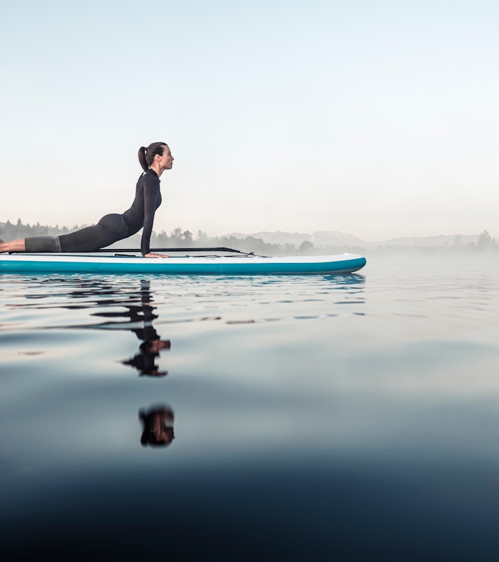 woman stretching and balancing on a paddle board