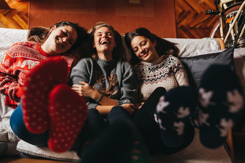 Three friends in Christmas sweaters and socks
