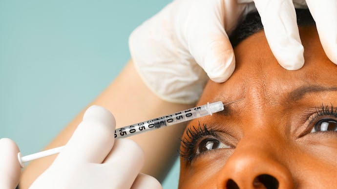 A woman getting Botox injected in her forehead area that could help her anxiety