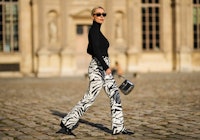 Model wears a black sweater and animal print zebra pants.