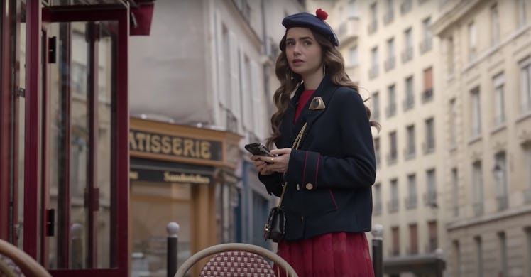 Emily from 'Emily in Paris' holds her phone, which she could use for the Duolingo promotion. 