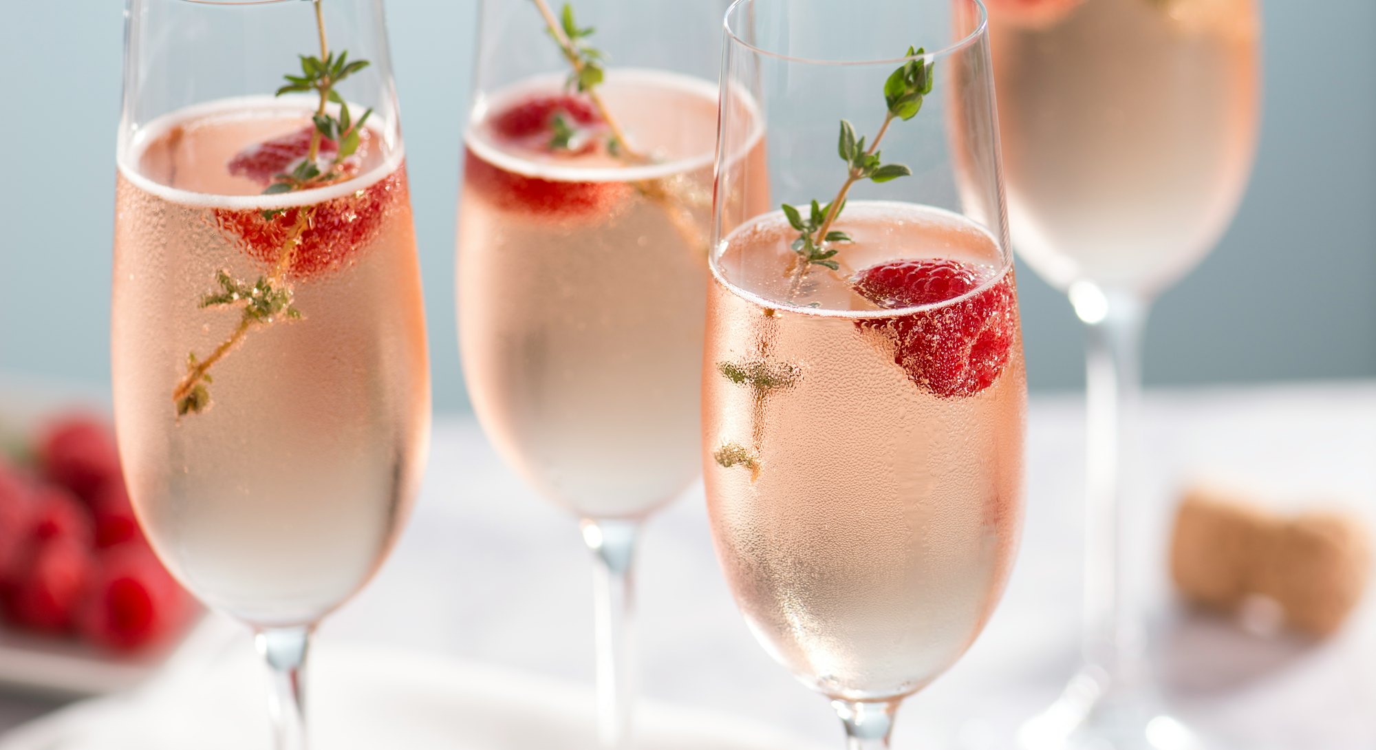 pink fizzy drink garnished with rosemary and thyme makes a delicious new year's mocktail