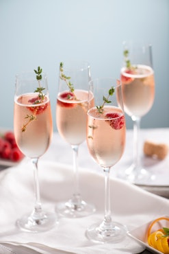 pink fizzy drink garnished with rosemary and thyme makes a delicious new year's mocktail