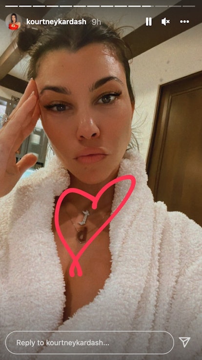 Kourtney Kardashian wearing a necklace with Travis Barker's initials. 