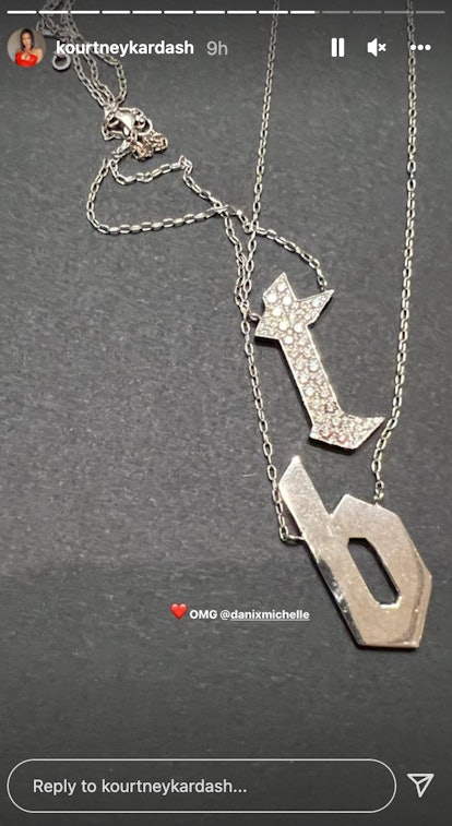 Kourtney Kardashian wearing a necklace with Travis Barker's initials. 