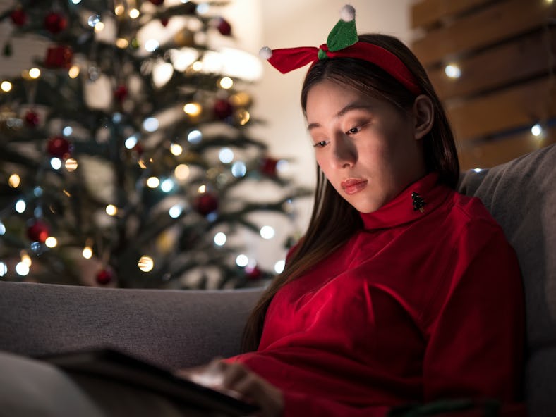 Young woman celebrating the holidays alone, knowing her zodiac sign's most likely to cry on Christma...