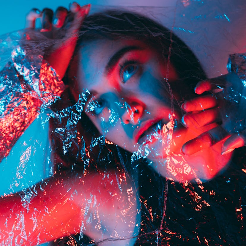 Young woman in colorful bright neon blue and purple lights during the January 2022 new moon in Capri...