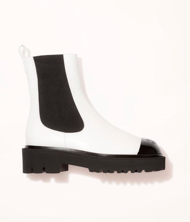 White combat ankle boots with black trim by Chanel