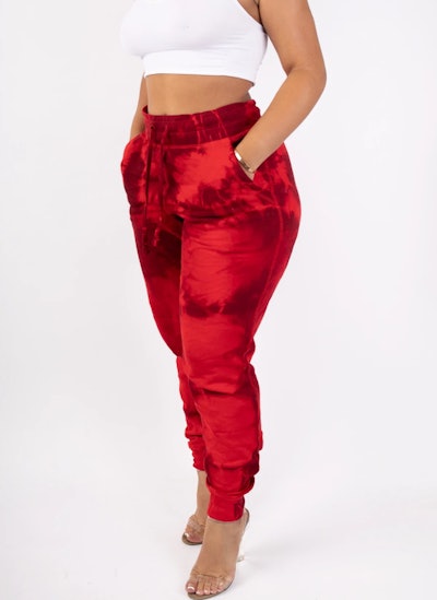 Woman standing, modeling red tie-dye joggers
