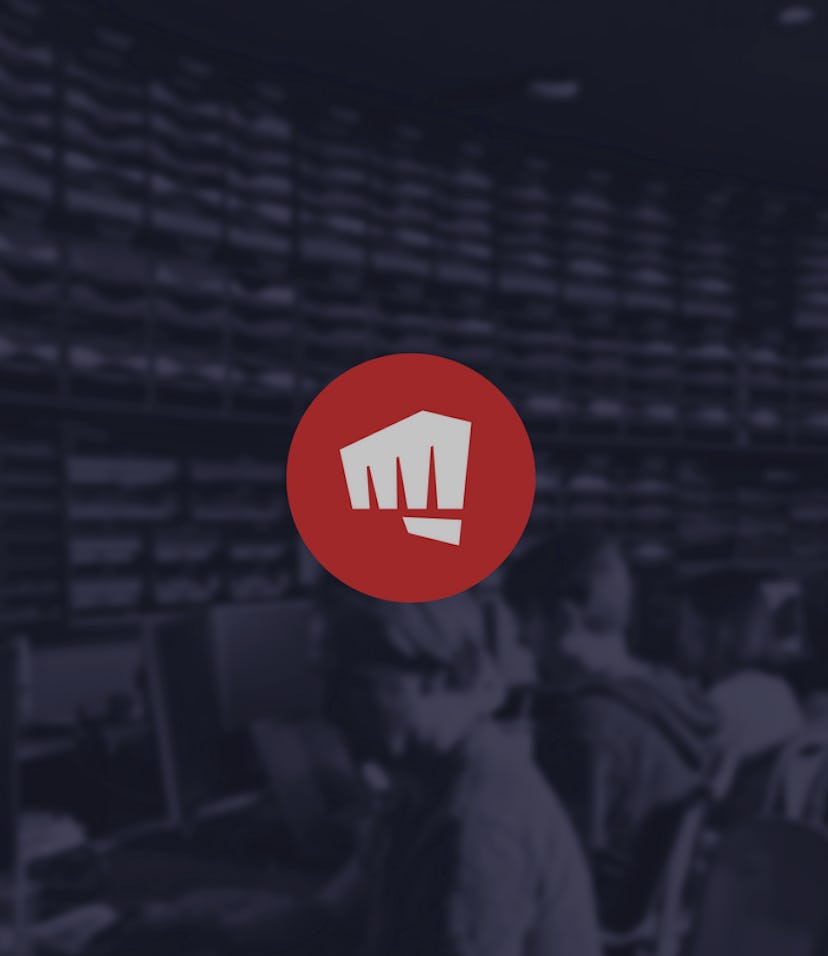 Riot Games' fist-bump logo with faded office view in background showing men at computers
