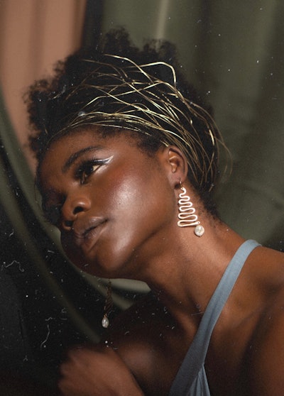 woman modeling statement earrings