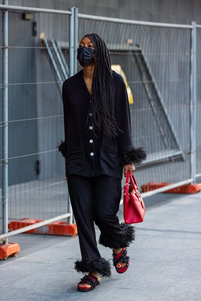 A fashion influencer wears a black pajama set to Milan Fashion Week.