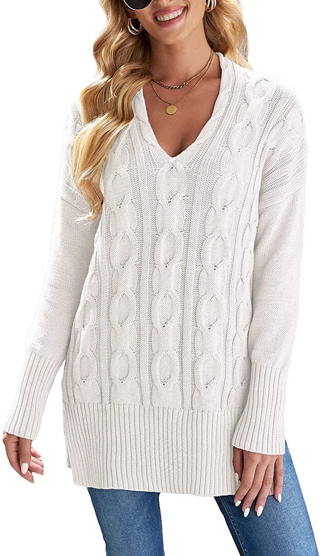 This cable-knit tunic sweater has a V-neck and oversize cuffs.