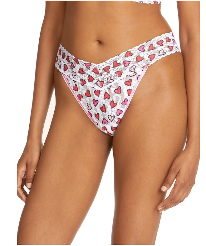 Image of a pair of white lace thong underwear with multicolor heart print.