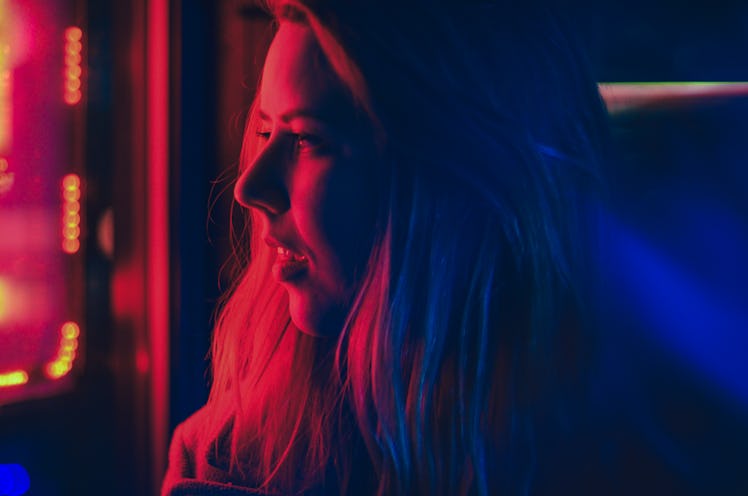 Young woman in red and blue lights after finding out the color of her aura.