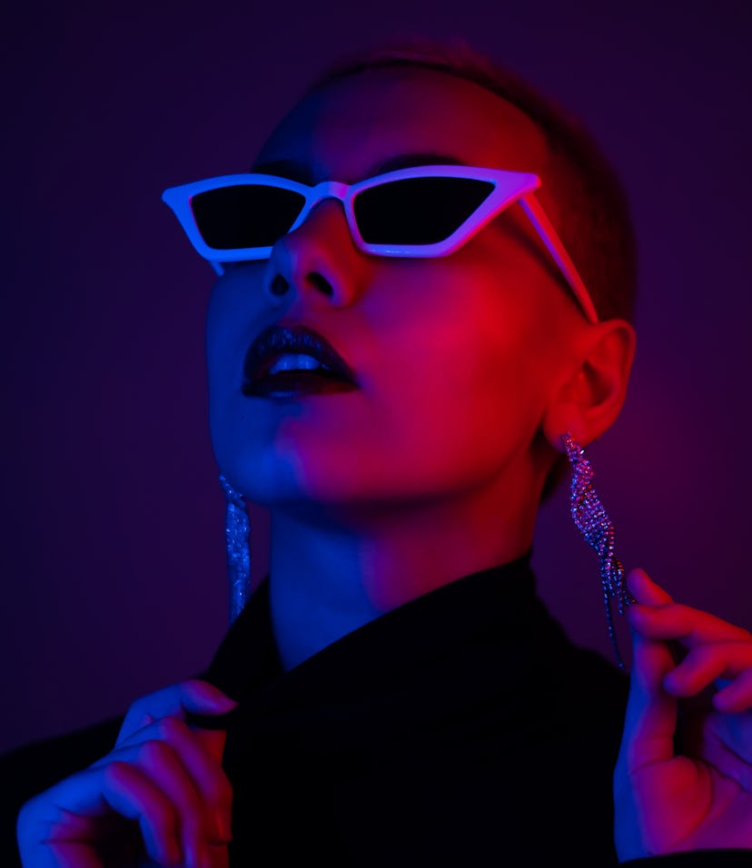 Young woman in blue and red lights after figuring out how to find her aura color.