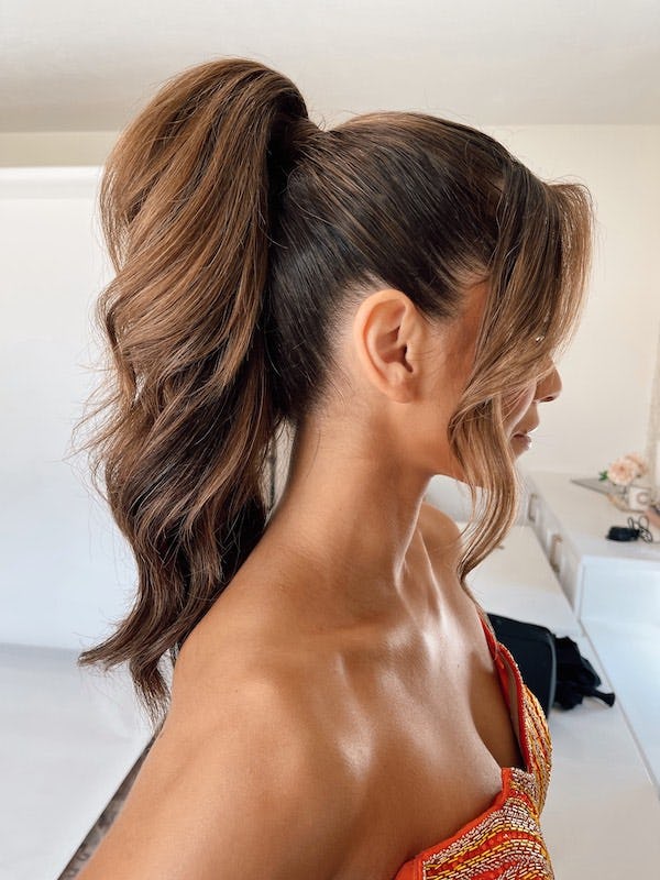 Brunette hair styled in a fluffy, wavy ponytail.