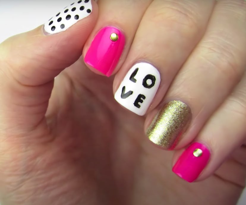 Close up of manicure in black, white, pink, and gold colors