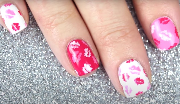 Close up of manicure; red, pink, and white nails with kisses 