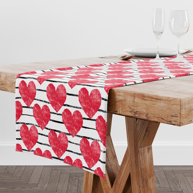This table runner with red hearts is a fun Valentine's Day decoration.