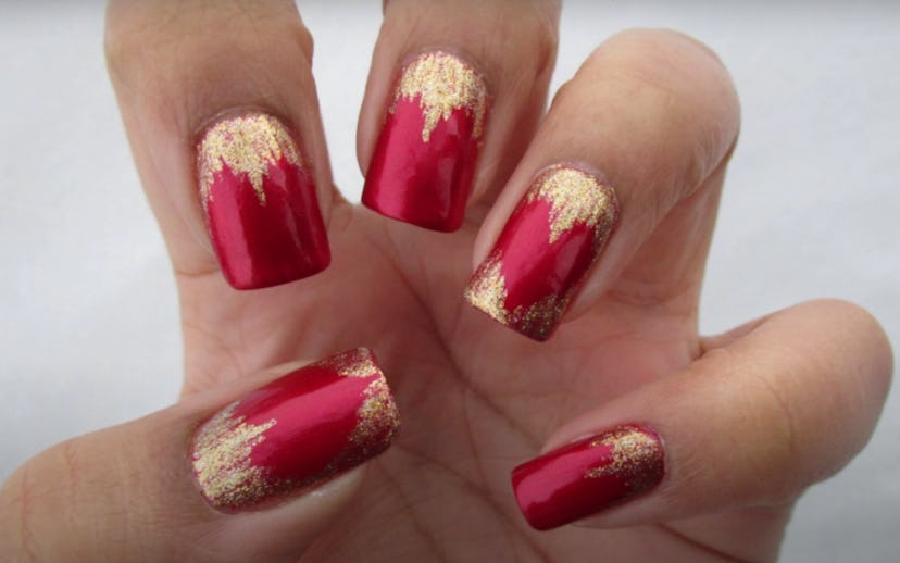 Close up of manicure; red polish with gold waterfall accent