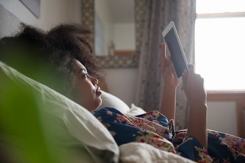 A woman reads on an e-reader.