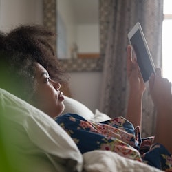 A woman reads on an e-reader.