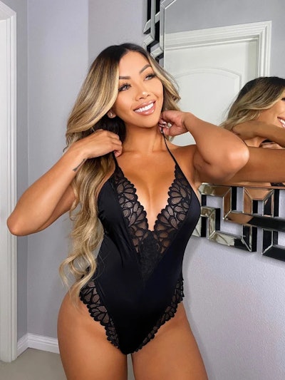 Woman modeling black one-piece lingerie