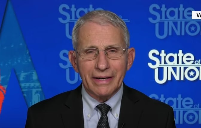 Dr. Fauci in a black suit, black tie and white shirt clapping back at the accusation about Aids and ...