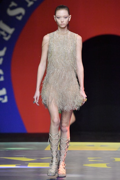 A model walks in a golden fringe dress during Dior's Spring/Summer 2022 show.