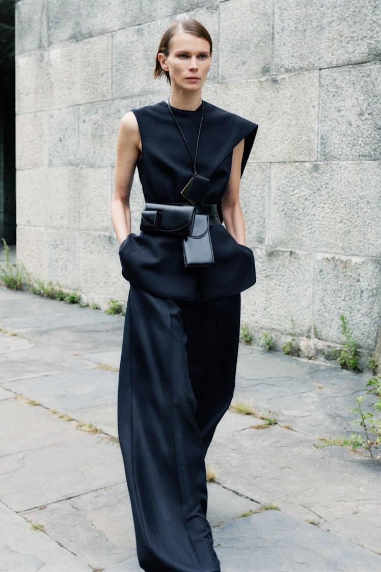 Model in black shirt and pants with belt bags from The Row.