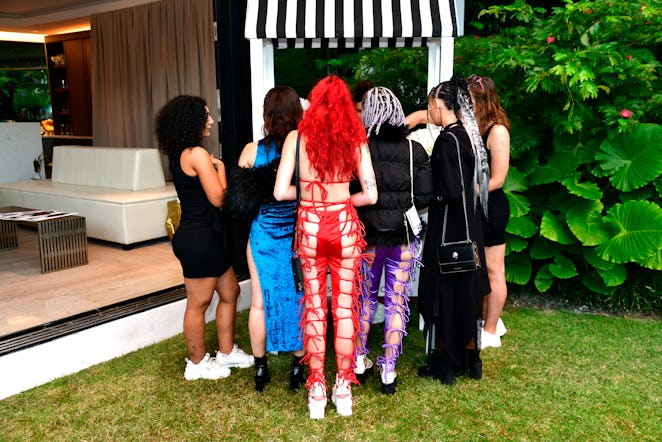 A group of women standing in front of a stand at Art Basel Miami