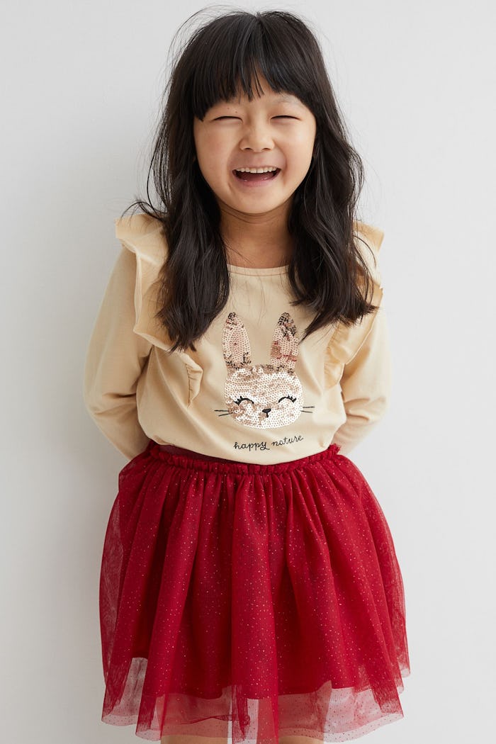 Little girl smiling, wearing Christmas outfit