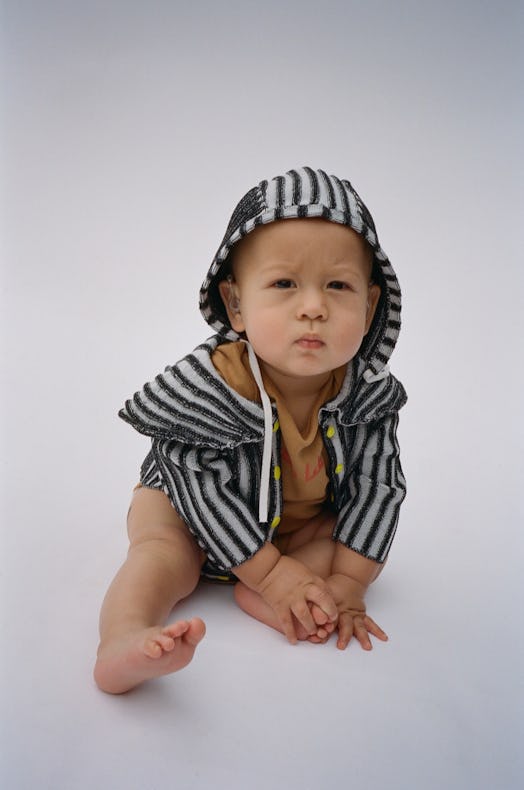 A young Eckhaus Latta Bambino model in a striped hoodie 