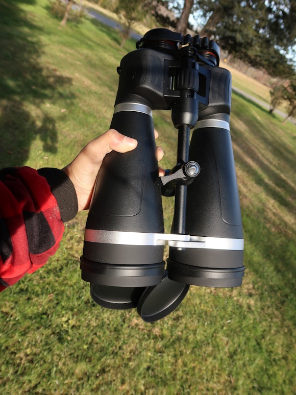 Large binoculars held in the author's hand for scale