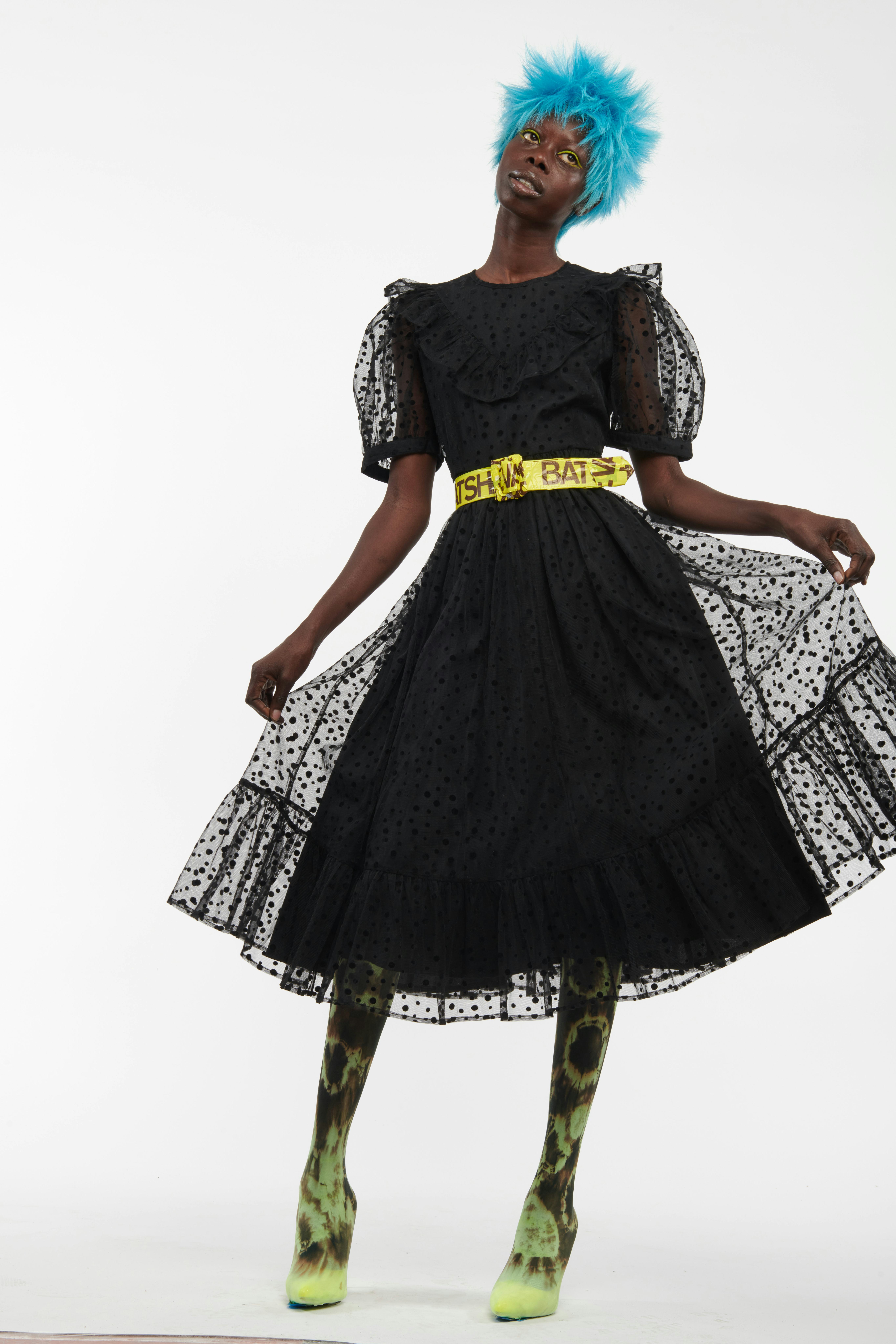 Batsheva black lacy dress and yellow caution tape belt