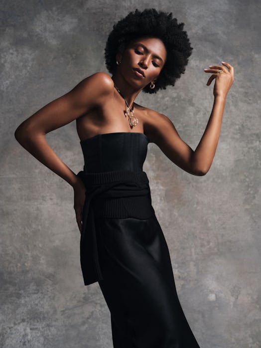 A dancer posing in jewelry and a black dress