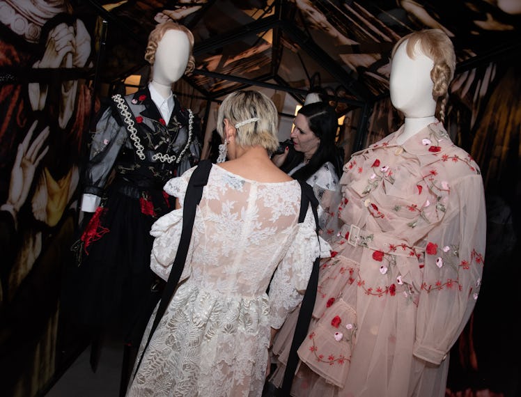 A woman looking at mannequins wearing Simone Rocha dresses
