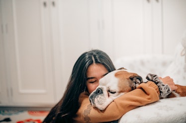Woman cuddling with dog